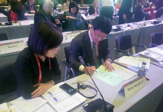 이승우 국가기술표준원장(오른쪽)이 지난 20일(현지시간) 남아프리카공화국 케이프타운에서 열린 국제표준화기구(ISO) 총회에서 이사국 선출 투표용지에 투표하고 있다. <국가기술표준원 제공>